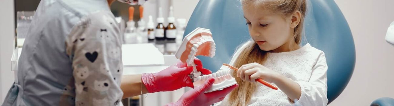 Cute little girl sitting in the dentist's office