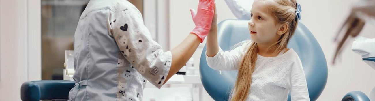 Cute little girl sitting in the dentist's office